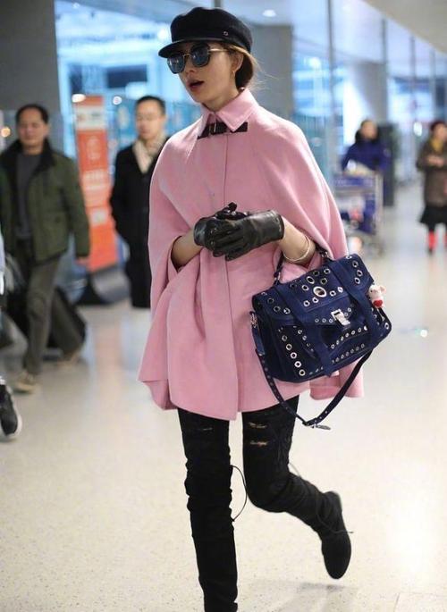 林志玲身着一件嫩嫩的粉色斗篷,样式简洁明了,搭配一双皮手套制造出